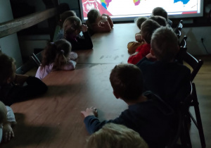 Dzieci oglądają na ekranie prezentację multimedialną