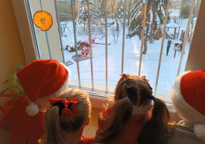 dzieci patrzą przez okno na Mikołaja