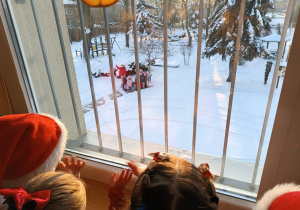 dzieci patrzą przez okno na Mikołaja