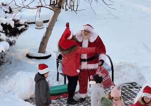 Pani Marzenka i dzieci witają Mikołaja w ogrodzie