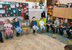 Dzieci siedzą na krzesełkach