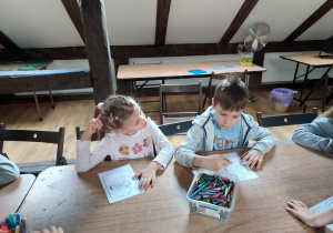 Ania i Mateusz kolorują na kartce szablon bałwanka