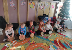 Siedmioro dzieci z grupy Ważki grają na bębnach