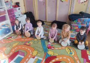 Sześcioro dzieci z grupy Biedronki gra na bębnach