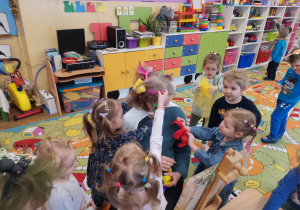 Kilkoro dzieci z grupy Biedronki i Pszczółki robią fryzurę pani Sylwii
