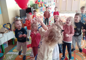 Dzieci próbują złapać balon