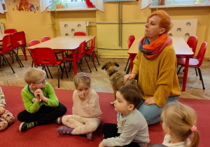 Pani Ania z pieskiem i dzieci siedzą na dywanie