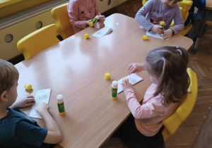 Dzieci przy stolikach robią pracę