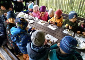 Dzieci z gr.IV jedzą upieczone ziemniaki