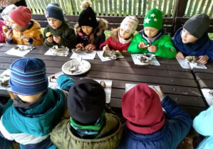 Dzieci z gr. IV jedzą upieczone ziemniaki
