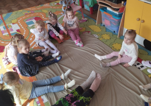 Dzieci z grupy Biedronki siedzą i pokazuja swoje skarpetki