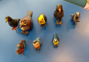 Na stole leżą figurki ptaków