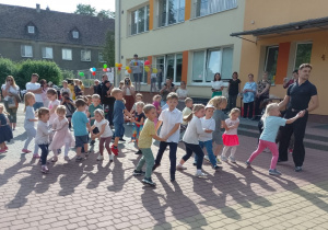 Dzieci z Panem Dawidem tańczą w parach polkę