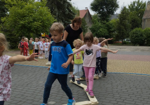 Dzieci przechodzą po równoważni