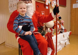 Mikołaj z Tymkiem na kolanach w holu przedszkola