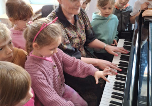 Dzieci z nauczycielką przy pianinie