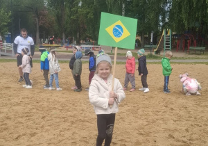 Dziewczynka trzymaw rękach flagę Brazyli