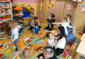 Mamy z dziećmi siedzą na dywanie