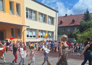 Dzieci z prowadzącymi idą jedno za drugim