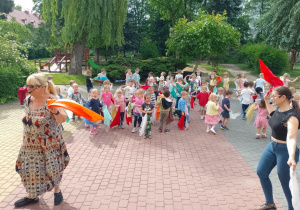Dwie panie prowadzące i dzieci z chustami podczas zabawy