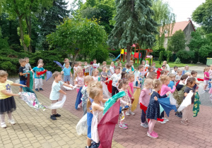 Dzieci trzymają w dłoniach chusty i poruszają nimi