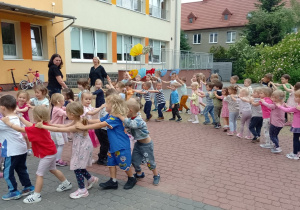 Dzieci z paniami poruszają się ustawione w pociąg