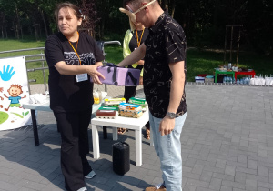 Pan Marcin Jaworski losuje z pudełka, które trzyma pani Ania przedmiot