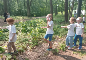 Czworo dzieci idzie przy linie z zakrytymi oczami