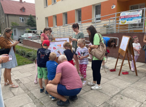 Rodzice z dziećmi podczas tworzenia obrazu wiosennej łąki