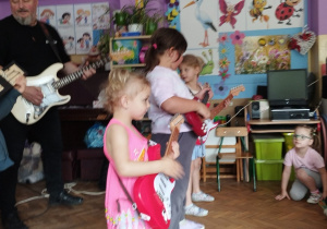 Trzy dziewczynki i gość grają na gitarach