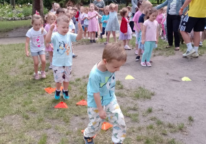 Dzieci podczas przeskoków przez pachołki