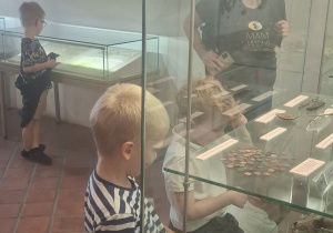 Kikoro dzieci ogląda ekspozycje w gablotach