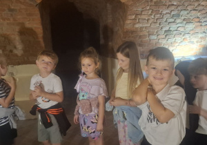 Dzieci stoją w podziemiach zamku