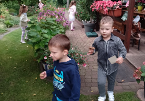Dwóch chłopców niesie grzybka w rękach