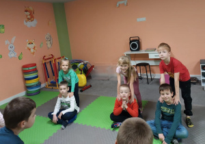 Dzieci w parach- jedno siedzi, drugie stoi z tyłu