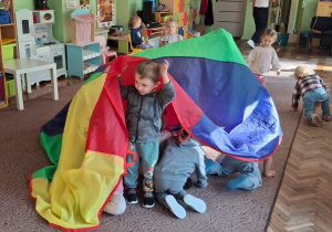 Dzieci chowają się pod chustą