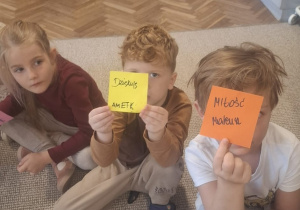 Dwóch chłopców trzyma karteczki z napisami