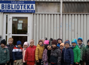 Dzieci stoją przed biblioteką