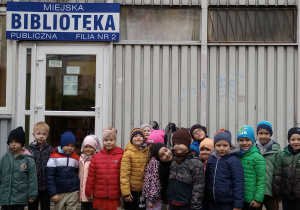 Dzieci stoją przed biblioteką