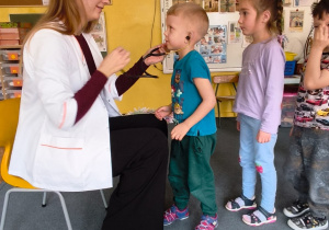 Pani doktor i chłopiec z założonym stetoskopem