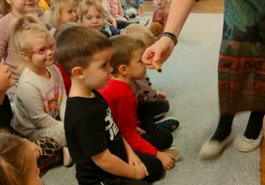 Prowadząca podaje chłopcu przyprawę do wąchania