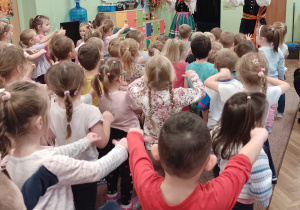 Para tancerzy i dzieci wyciągają ręce do przodu