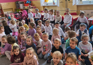 Dzieci siedzą na dywanie podczas spotkania