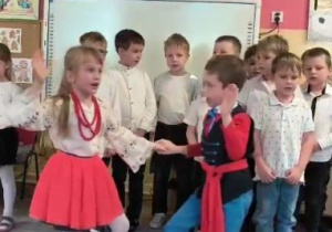 Dziewczynka i chłopiec tańczą kujawiaka