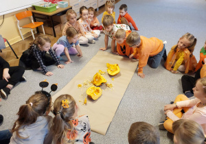 Dzieci patrzą na pokrojoną dynię