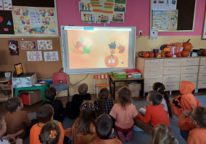 Dzieci oglądają film edukacyjny na tablicy multimedialnej