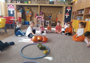 Chłopiec liczy dynie w obręczy