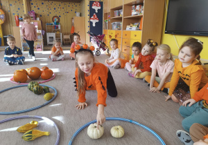 Dziewczynka dotyka dynię w obręczy