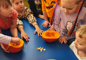 Dzieci oglądają dynie i pestki na stole