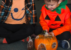 Dwóch chłopców patrzy na ozdobioną dynię